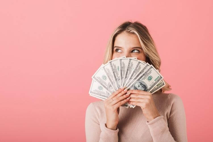 дівчина тримає гроші