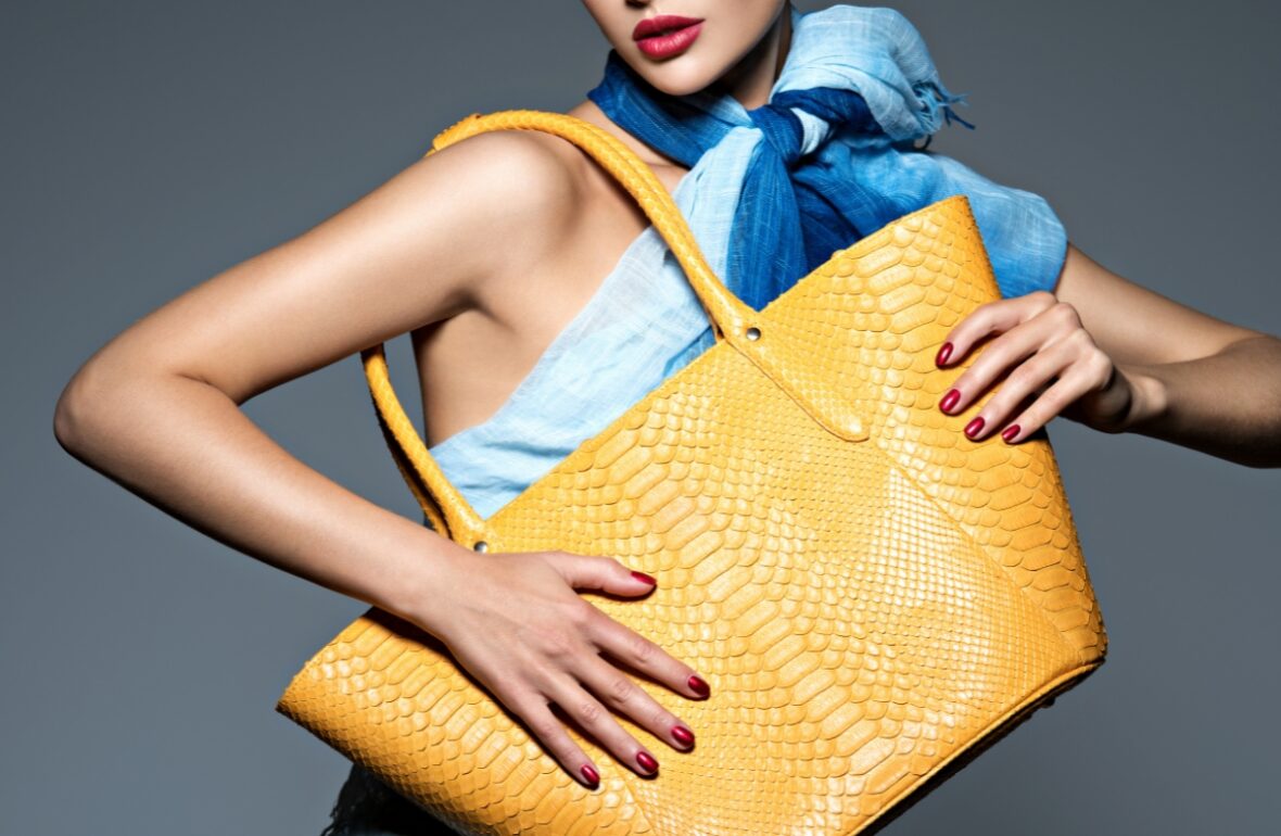 жінка тримає велику жовту сумку