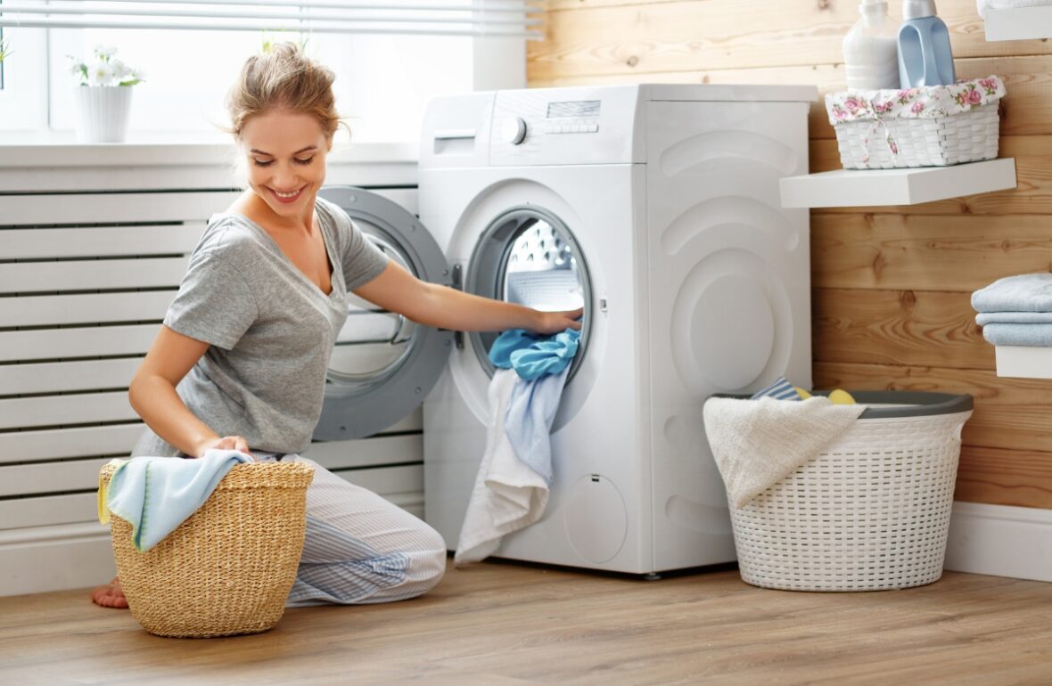 жінка завантажує пральну машинку