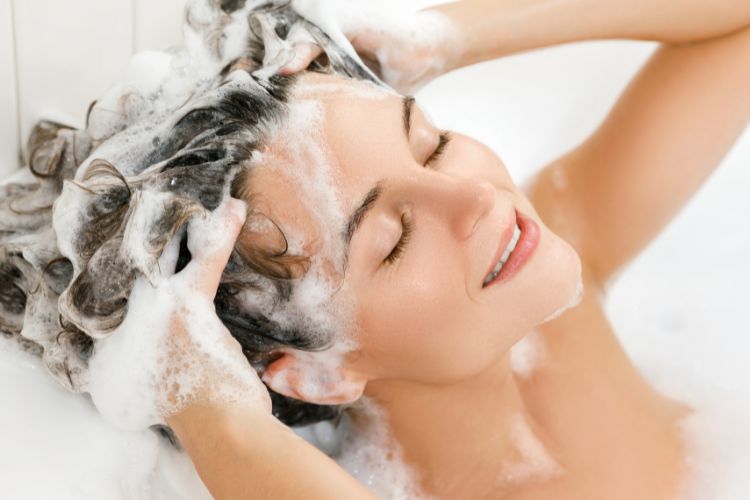 жінка миє голову