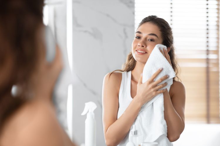 дівчина витирає обличчя білим рушником