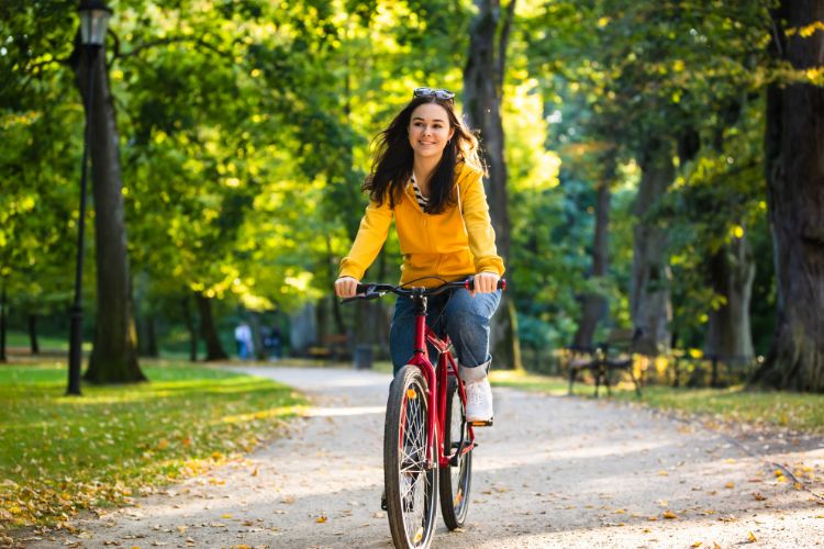 дівчина їде на велосипеді в парку