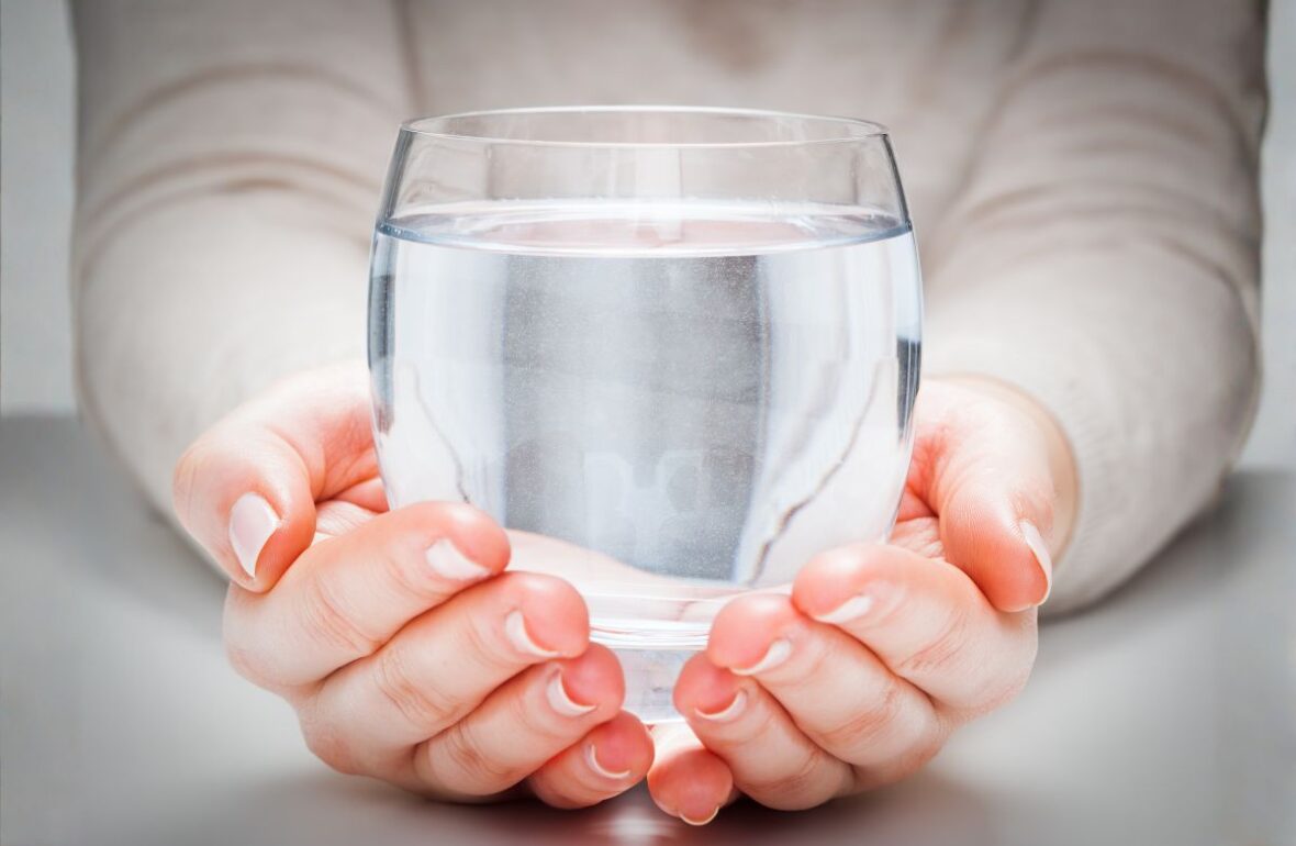 жінка тримає склянку чистої води